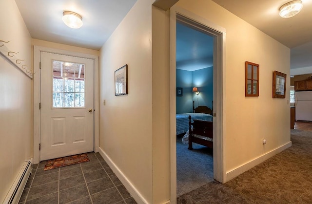 doorway featuring baseboards, dark colored carpet, and a baseboard heating unit