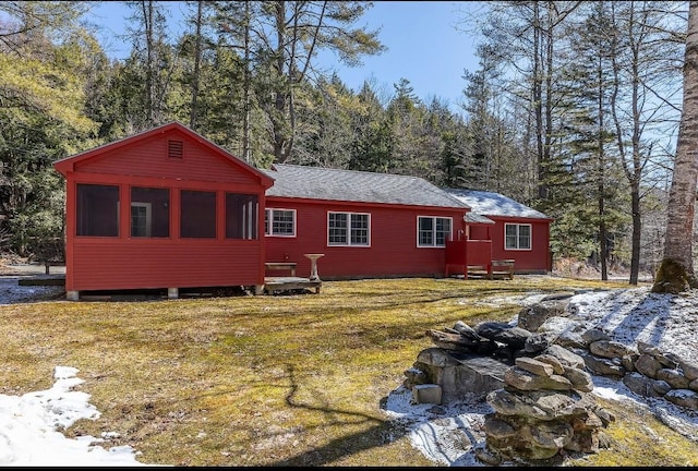 rear view of property with a sunroom and a yard