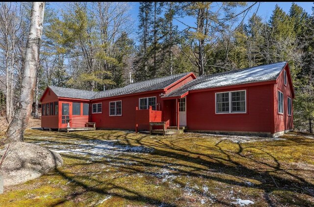view of front of home with a front lawn and a sunroom