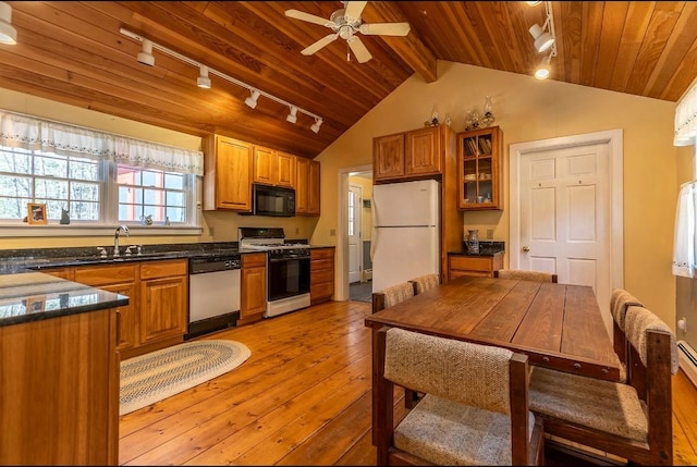 kitchen featuring a sink, rail lighting, white appliances, light wood-style flooring, and vaulted ceiling with beams