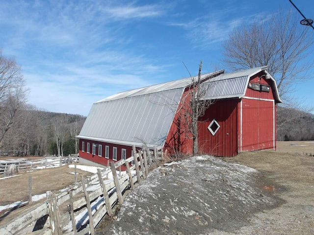snow covered structure featuring a barn and an outdoor structure