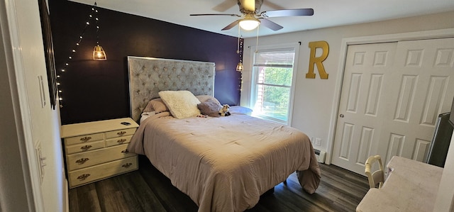 bedroom featuring dark wood-type flooring, ceiling fan, baseboard heating, and a closet