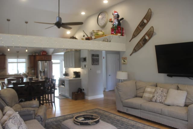living room featuring light wood-type flooring, a ceiling fan, high vaulted ceiling, and recessed lighting