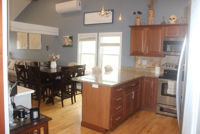 kitchen with decorative backsplash, light wood-type flooring, a peninsula, an AC wall unit, and appliances with stainless steel finishes