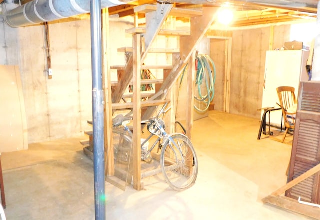 unfinished basement featuring stairway