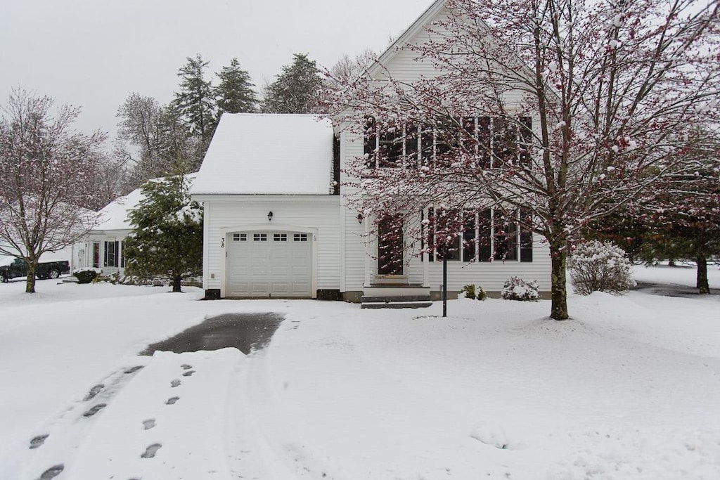 snow covered property featuring a garage