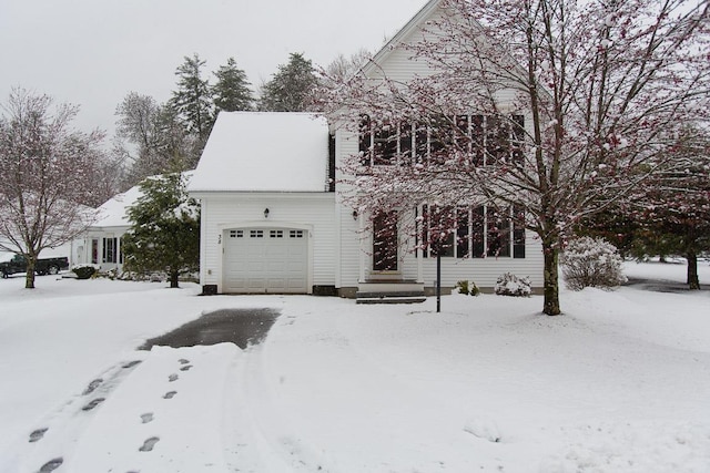 snow covered property featuring a garage