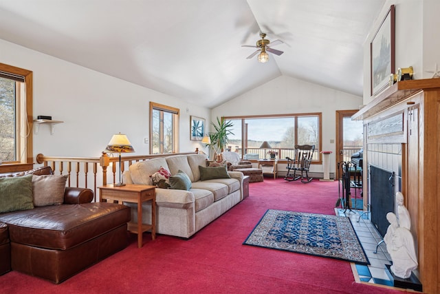 living room featuring a tile fireplace, a ceiling fan, vaulted ceiling, and carpet floors