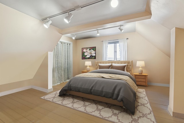 bedroom with track lighting and baseboards