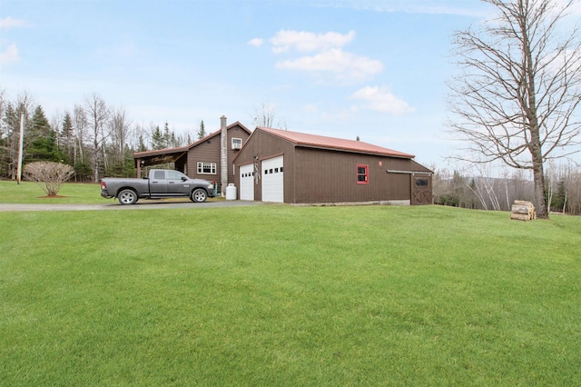 view of home's exterior featuring an outbuilding, a garage, a lawn, and a chimney