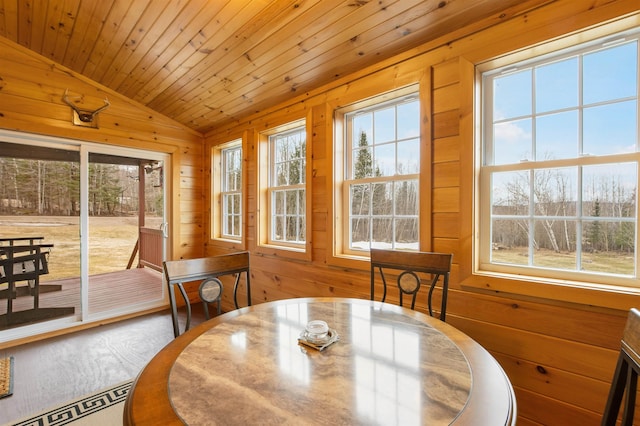dining room featuring wooden walls, wood ceiling, baseboard heating, and lofted ceiling