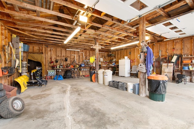 garage featuring a workshop area and freestanding refrigerator