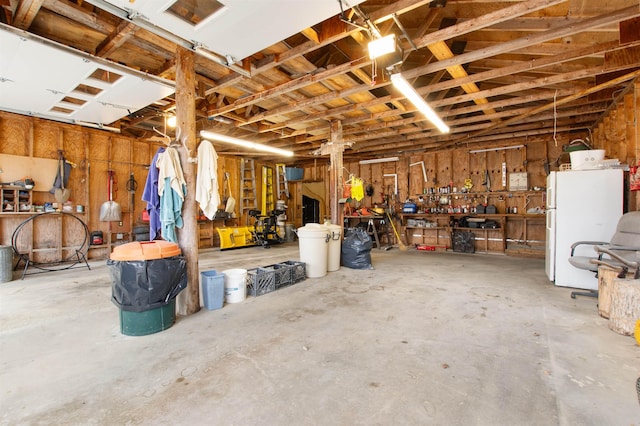 garage featuring a workshop area and freestanding refrigerator