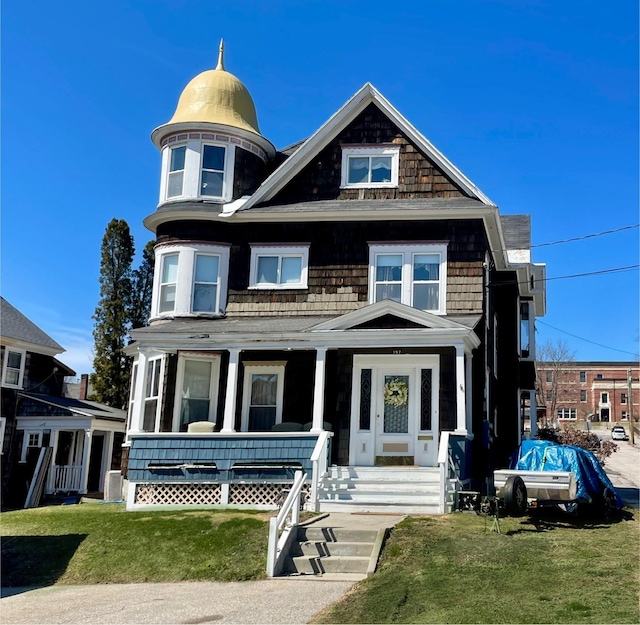 victorian home with a porch and a front lawn