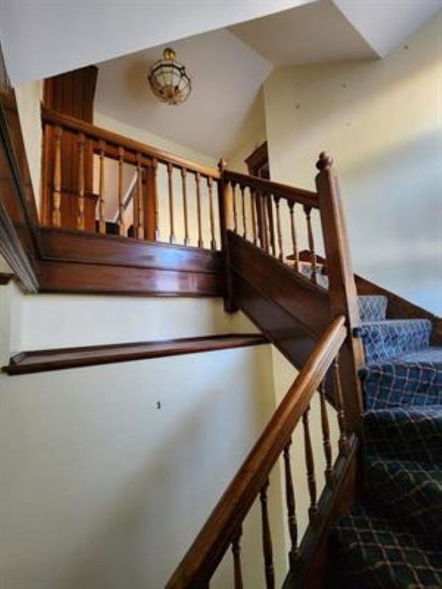 staircase featuring vaulted ceiling