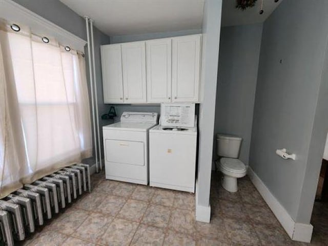 laundry area with baseboards, laundry area, washing machine and dryer, and radiator