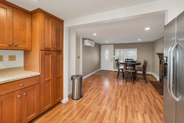 12 Wildwood Rd, Gilford, NH 03249 - kitchen featuring stainless steel fridge with ice dispenser, baseboards, a wall mounted AC, and brown cabinets