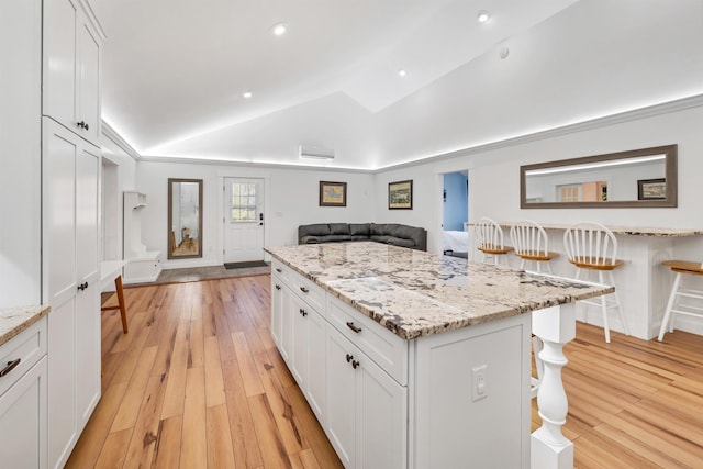 12 Wildwood Rd, Gilford, NH 03249 - kitchen with white cabinetry, light wood-type flooring, and a breakfast bar