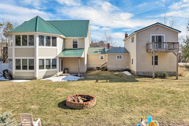 12 Wildwood Rd, Gilford, NH 03249 - rear view of house featuring metal roof, a fire pit, and a lawn
