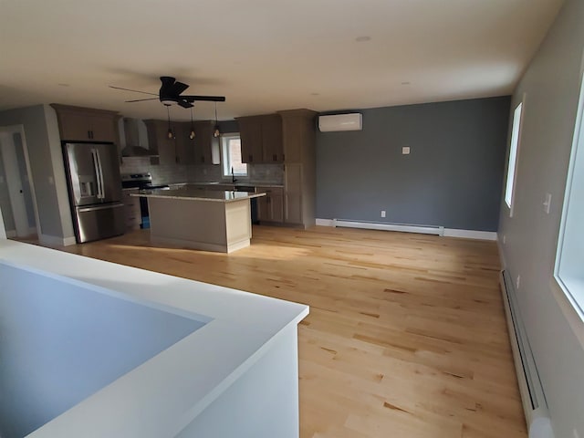1761 US Route 2, East Montpelier, VT 05651 - kitchen with a baseboard heating unit, a wall mounted air conditioner, wall chimney range hood, stainless steel appliances, and a baseboard radiator
