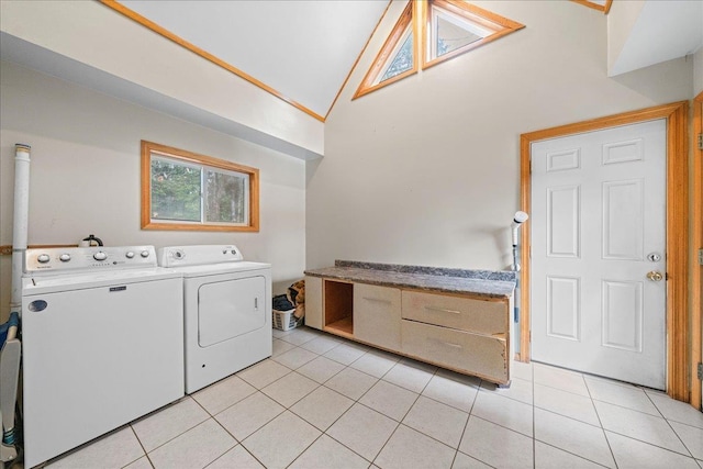 laundry area featuring washing machine and clothes dryer, light tile patterned flooring, laundry area, and a high ceiling
