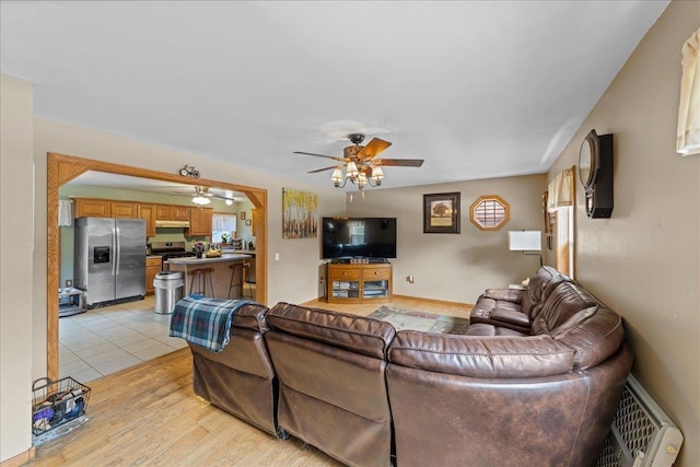 living area featuring light wood-style flooring and ceiling fan