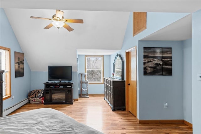 bedroom with baseboard heating, light wood-type flooring, baseboards, and lofted ceiling