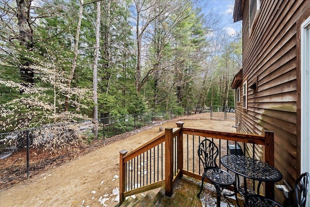 deck featuring a wooded view and fence