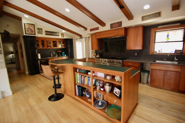 kitchen featuring a sink, backsplash, dark countertops, high end range, and recessed lighting