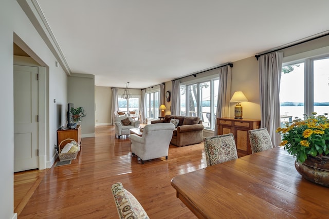 dining space with baseboards, a notable chandelier, and light wood-style floors