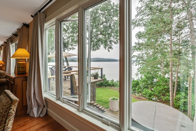 doorway to outside featuring a water view and wood finished floors