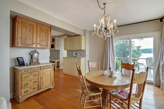 dining space with light wood finished floors and a notable chandelier
