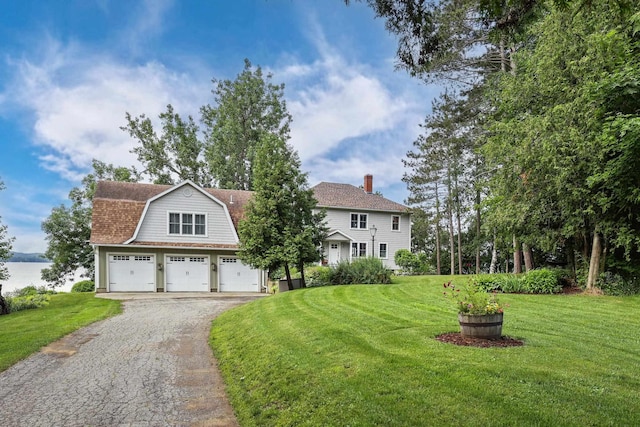 view of front of house with driveway, a front lawn, a water view, a gambrel roof, and a shingled roof
