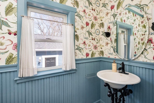 bathroom with wallpapered walls and a wainscoted wall