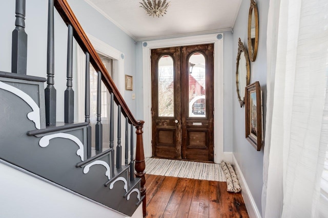 entryway featuring stairs, hardwood / wood-style flooring, baseboards, and ornamental molding