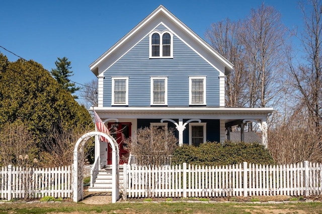 country-style home with covered porch and a fenced front yard