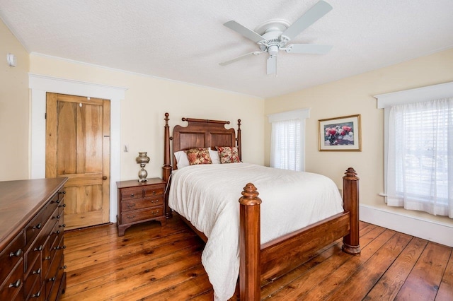 bedroom featuring hardwood / wood-style flooring, multiple windows, and ceiling fan