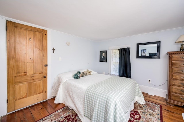bedroom featuring wood finished floors, baseboards, and ornamental molding