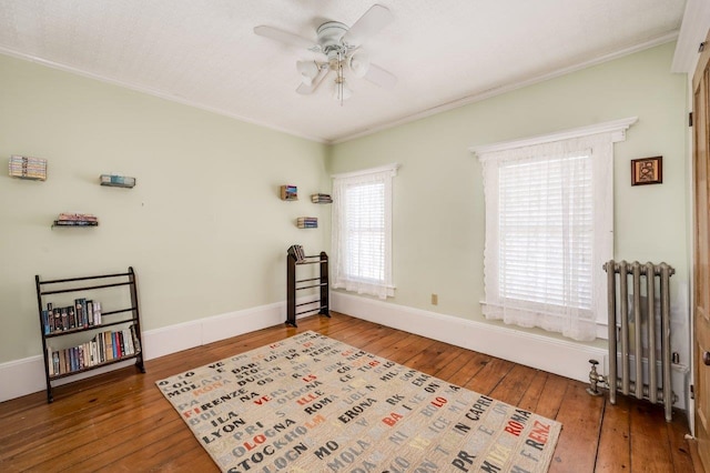 interior space featuring crown molding, radiator, ceiling fan, and wood-type flooring
