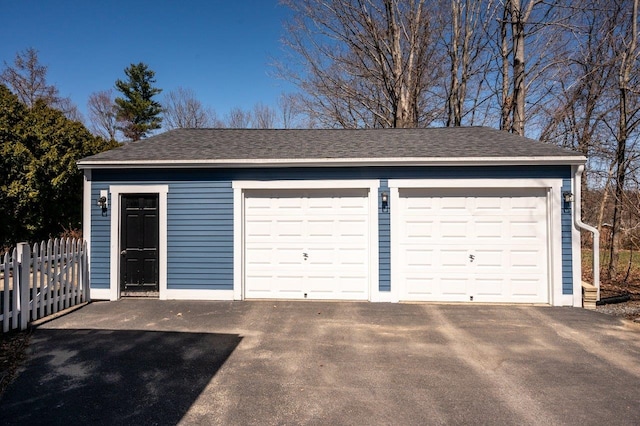 detached garage featuring fence
