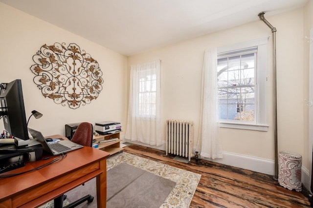 home office featuring baseboards, radiator, and wood finished floors