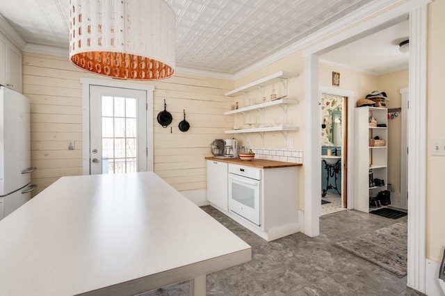 kitchen featuring wood counters, white appliances, crown molding, open shelves, and wood walls