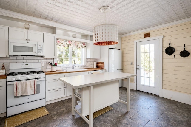 kitchen featuring a sink, open shelves, white appliances, and plenty of natural light