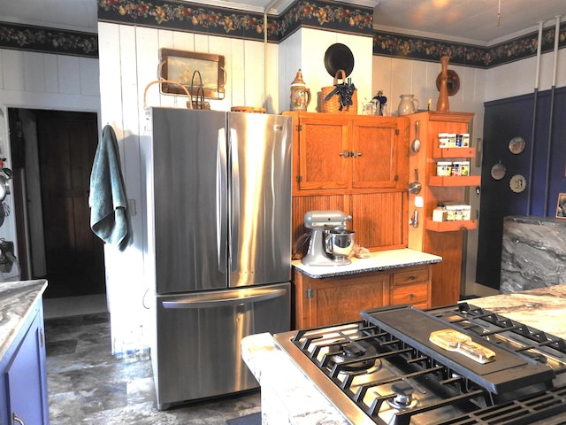 kitchen with light countertops, stove, brown cabinets, and freestanding refrigerator