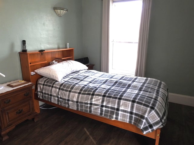 bedroom with dark wood-style flooring