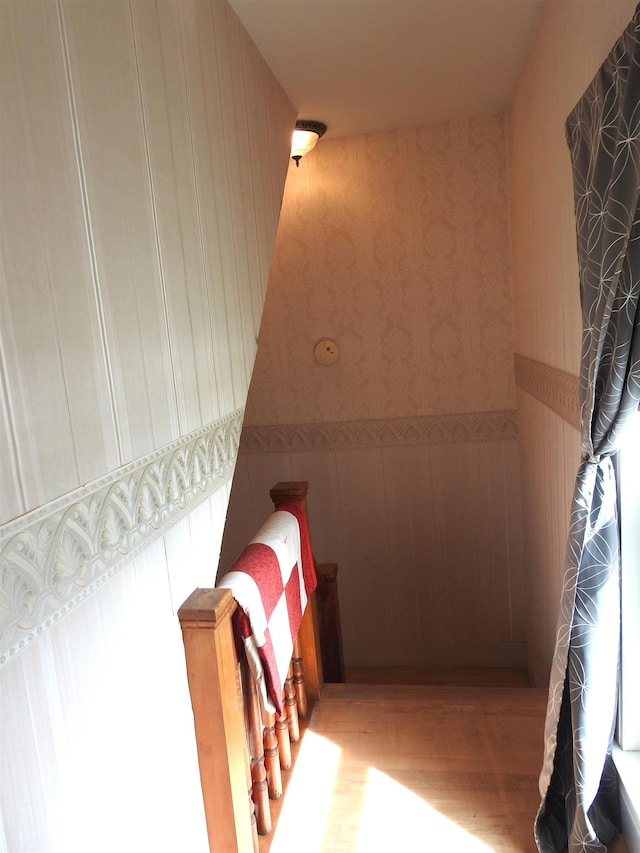 interior space featuring wainscoting, wood finished floors, and wallpapered walls