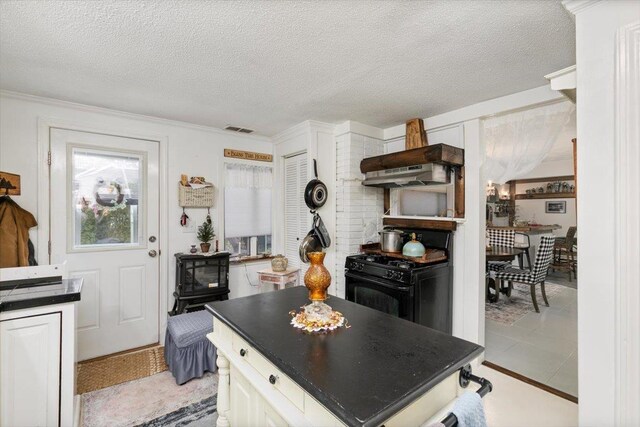117A Chases Grove Rd, Derry, NH 03038 - kitchen with a textured ceiling, visible vents, under cabinet range hood, dark countertops, and black gas range