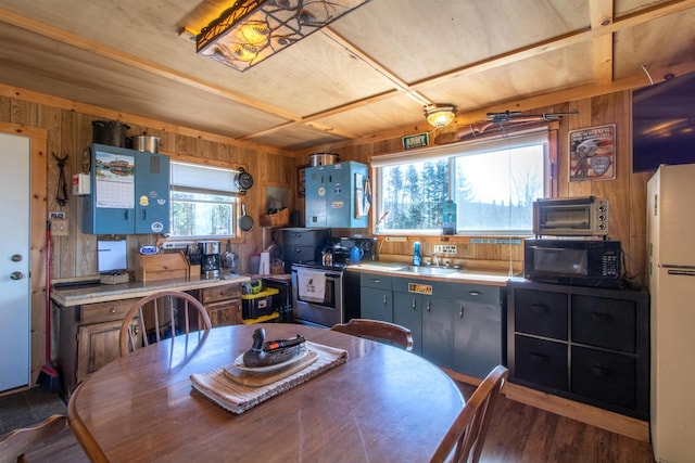 195 Curtis Rd, Morgan, VT 05853 - kitchen featuring black microwave, freestanding refrigerator, stainless steel electric range oven, wood walls, and wood finished floors