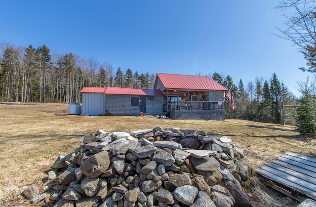 195 Curtis Rd, Morgan, VT 05853 - back of house with a lawn, a wooden deck, a metal roof, and a forest view