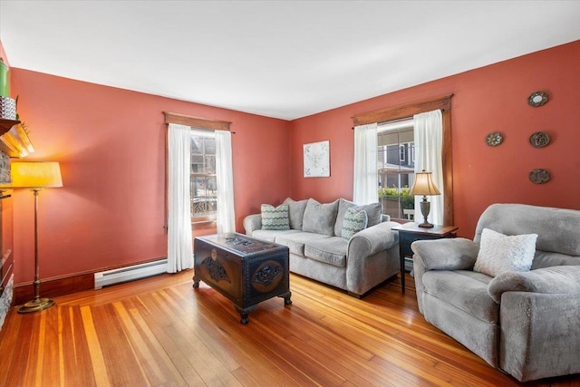 living area featuring wood-type flooring, baseboards, and a baseboard heating unit